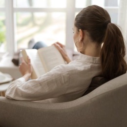 a woman reading a book in a chair