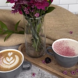 a table with a cup of coffee and flowers