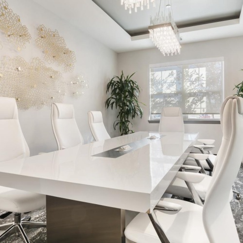 a room with a table, chairs and plants